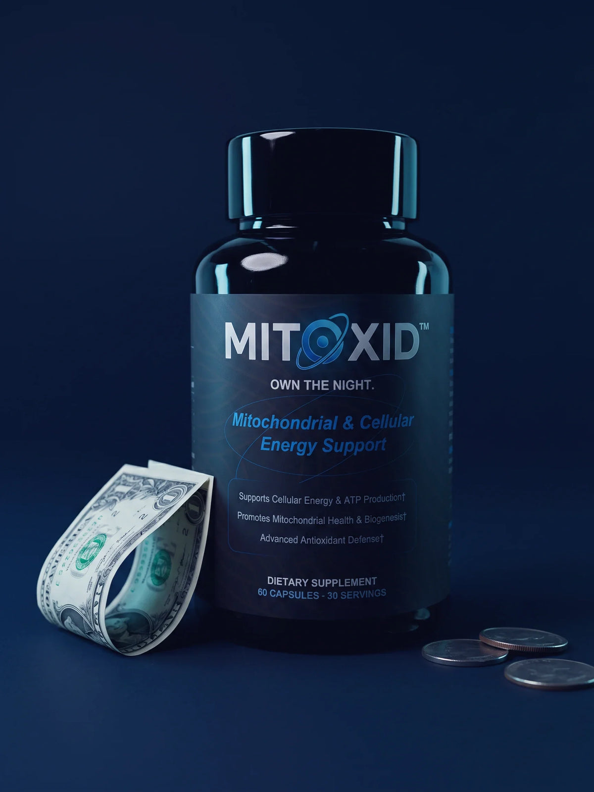 A Mitoxid bottle standing on a deep navy surface, with a folded one dollar bill curled beside it and three coins at its base