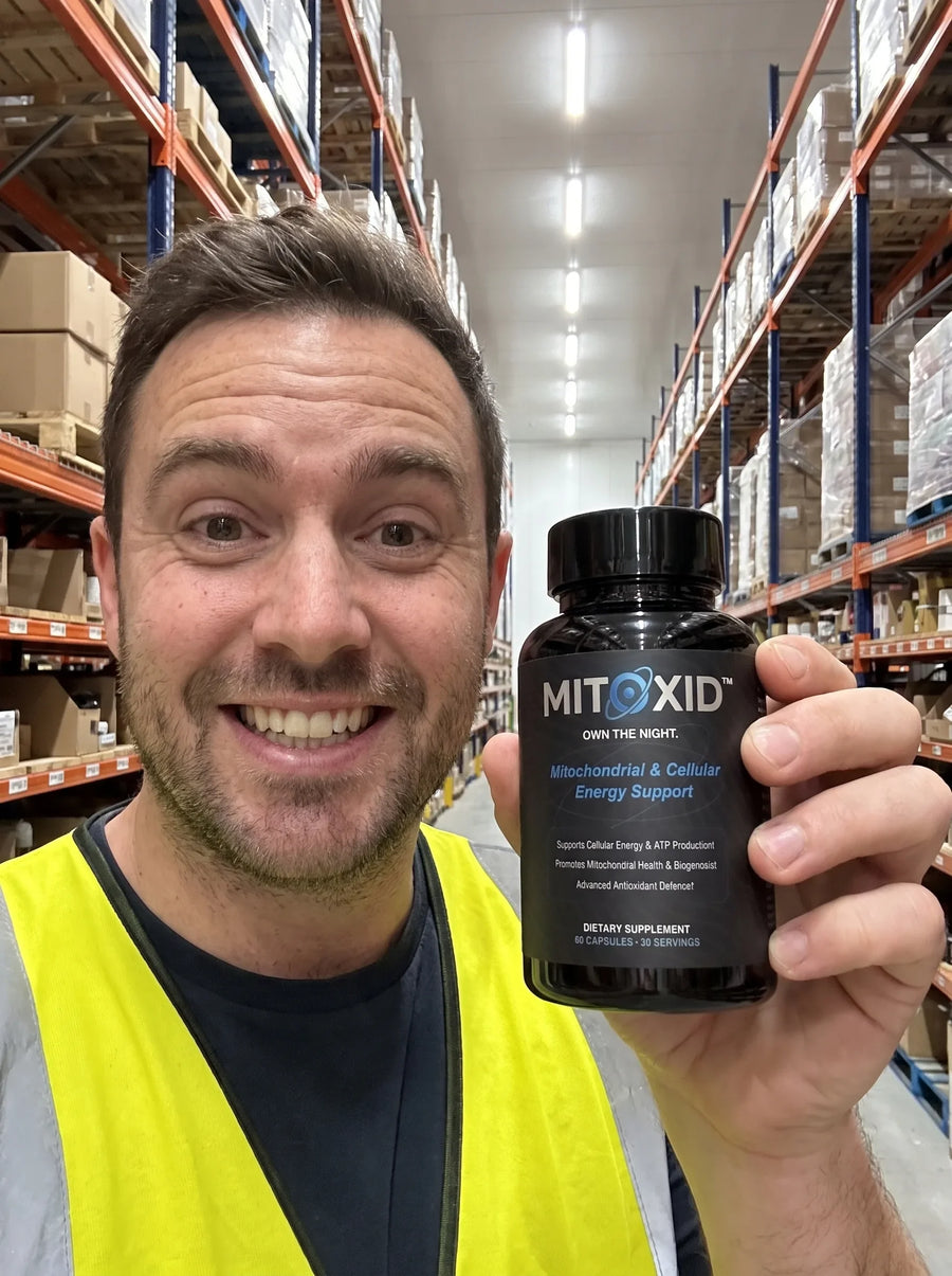 Customer photo: a warehouse worker in hi vis holding the Mitoxid bottle in a racking aisle