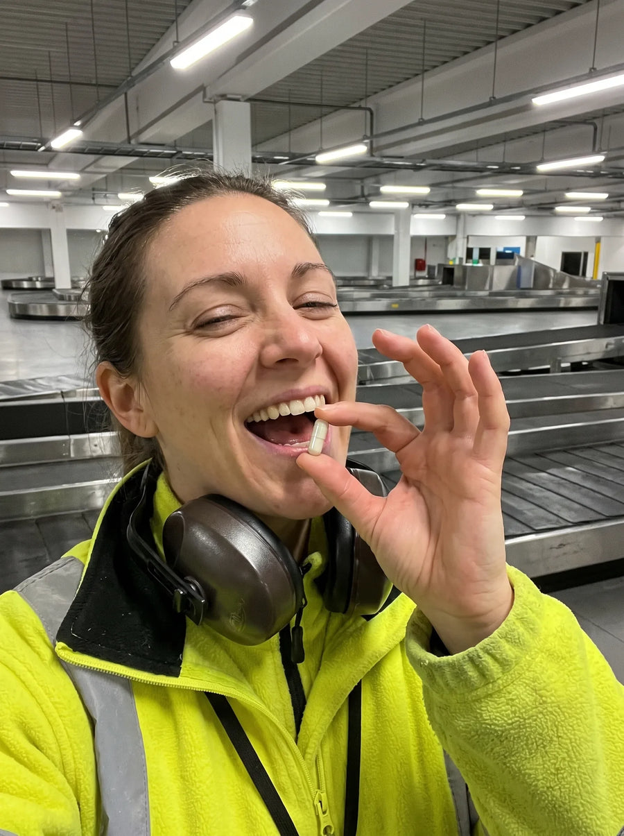 Customer photo: an airport baggage handler in ear defenders taking a Mitoxid capsule